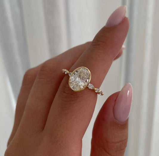 Gold ring with a large diamond on a hand against a white background