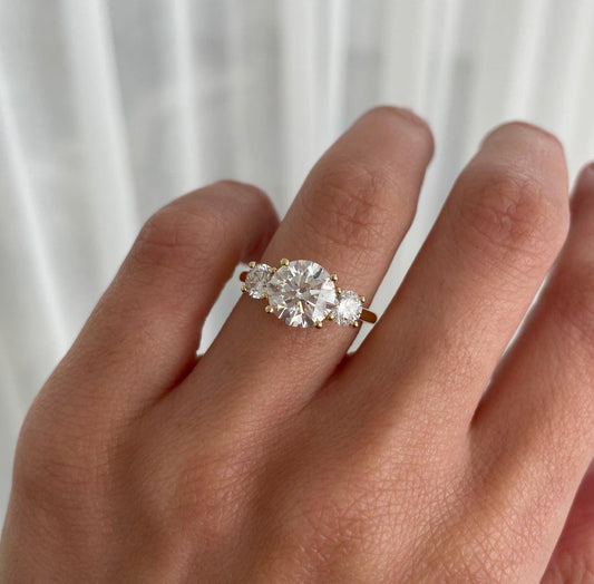 Diamond ring on a finger with a neutral background